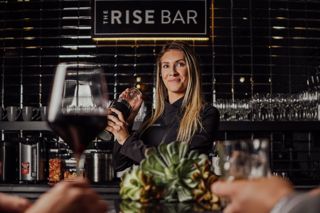 Woman bartending at The Rise Bar at The Refuge Spa